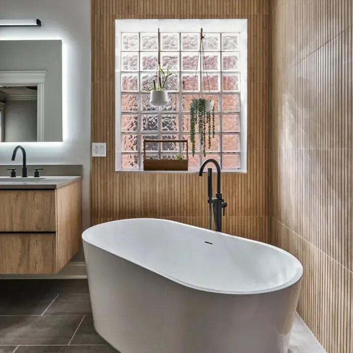 Natural spa-like bathroom with white freestanding tub and floating vanity
