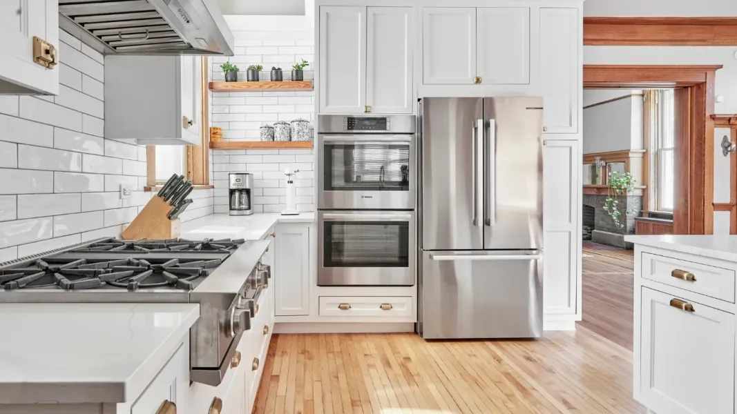 Modern kitchen with white cabinets, large island and black stainless steel fixtures